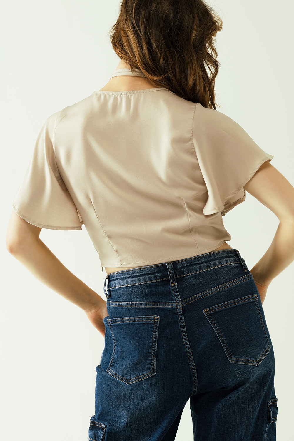 Beige V-neck crop top with short sleeves and a flower detail on the neck Q2 Tops BoutiqueLua