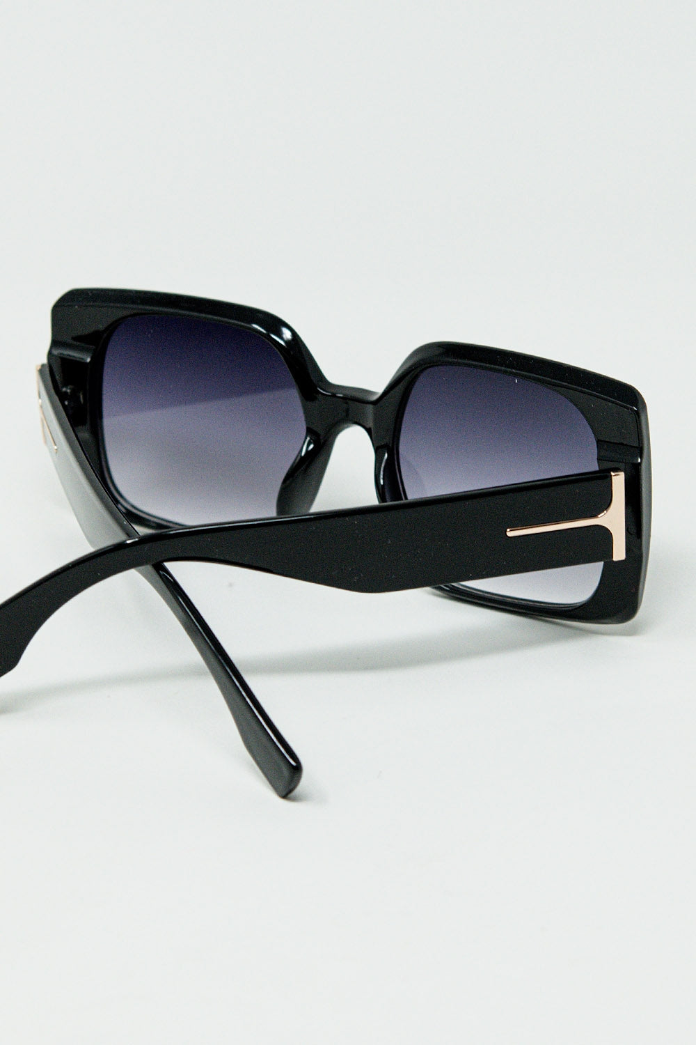 Black square sunglasses with gold detail on the side