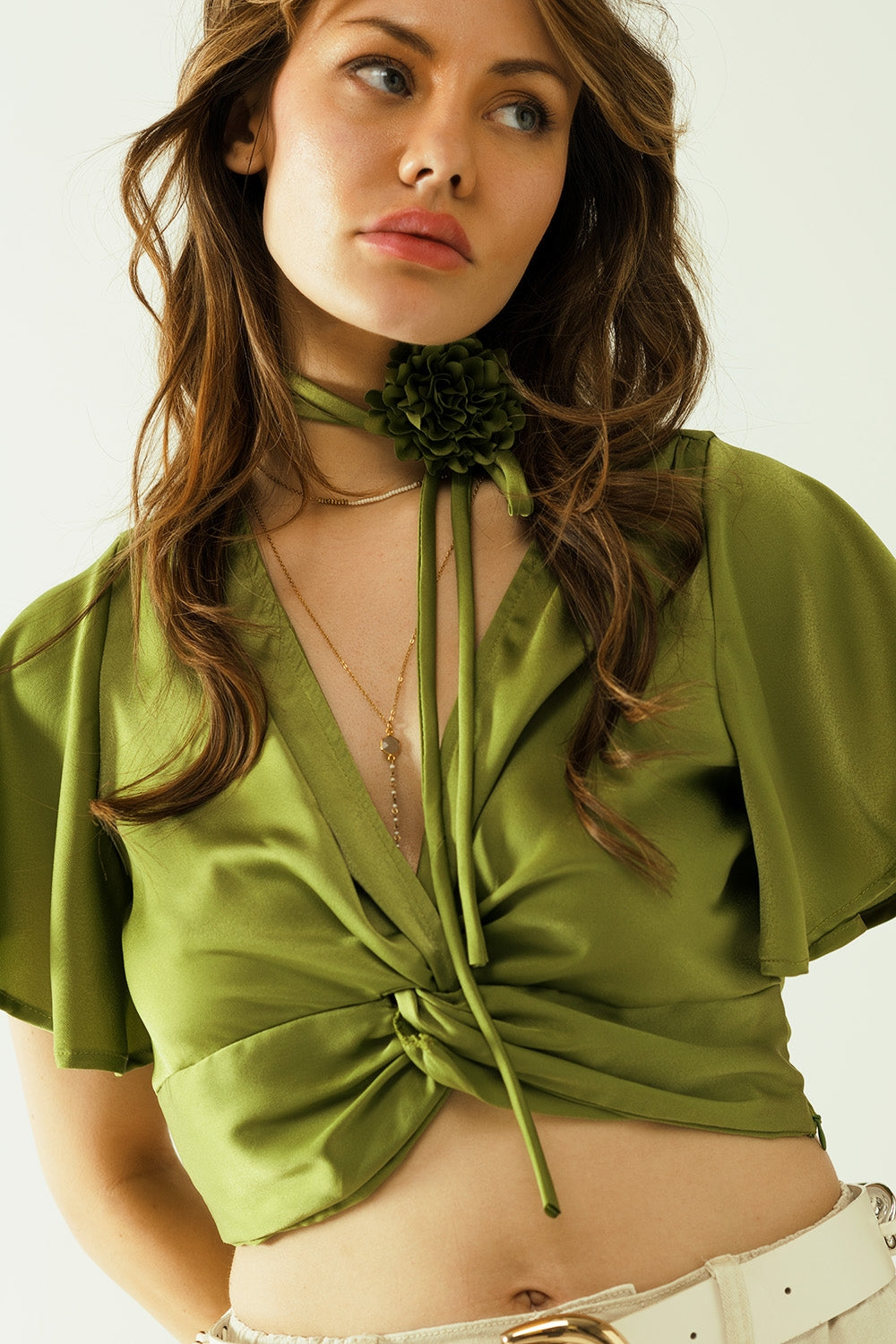 Green V-neck crop top with short sleeves and a flower detail on the neck Q2 Tops BoutiqueLua