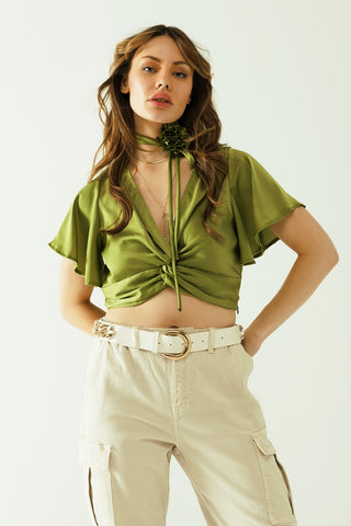 Green V-neck crop top with short sleeves and a flower detail on the neck